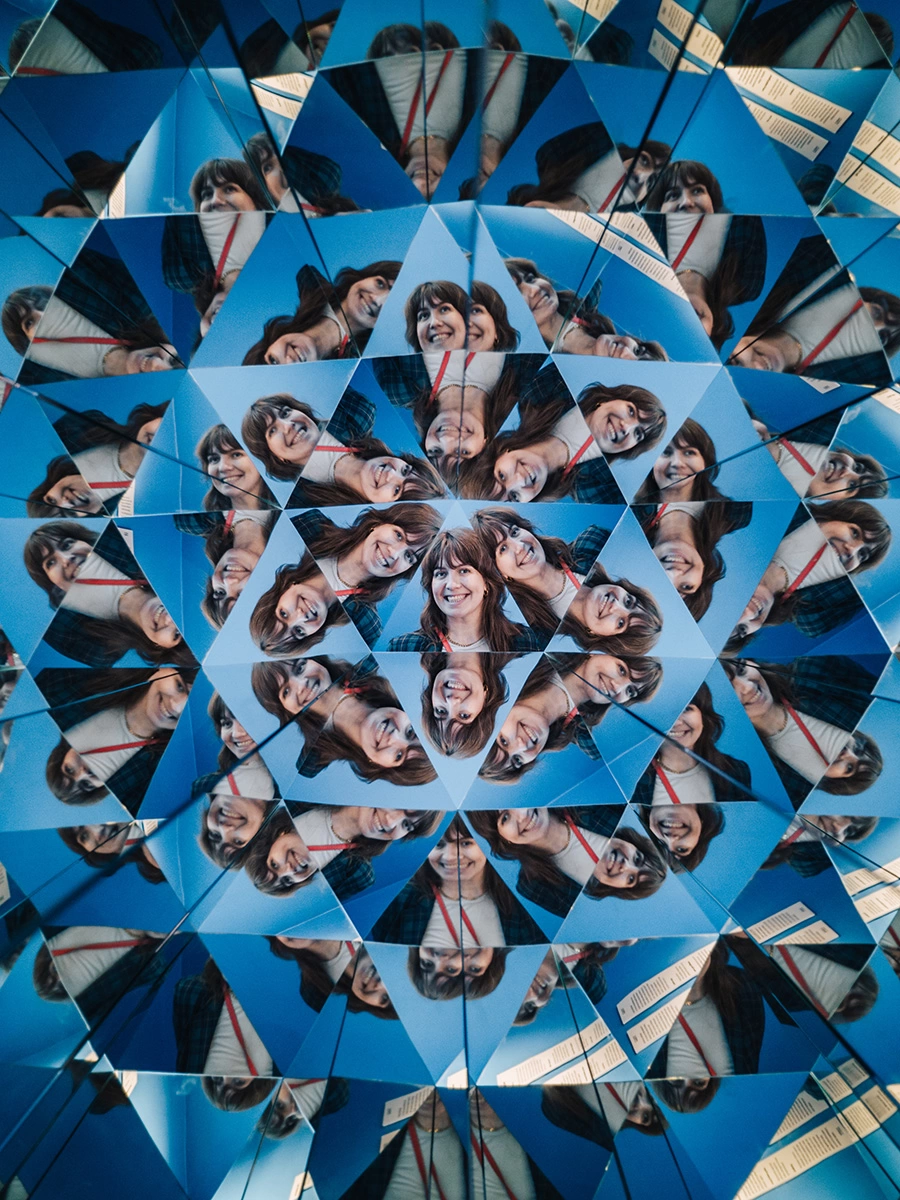A young businesswoman's face is seen in multiple reflections of a Kaleidoscope at the Museum of Illusions Copenhagen.