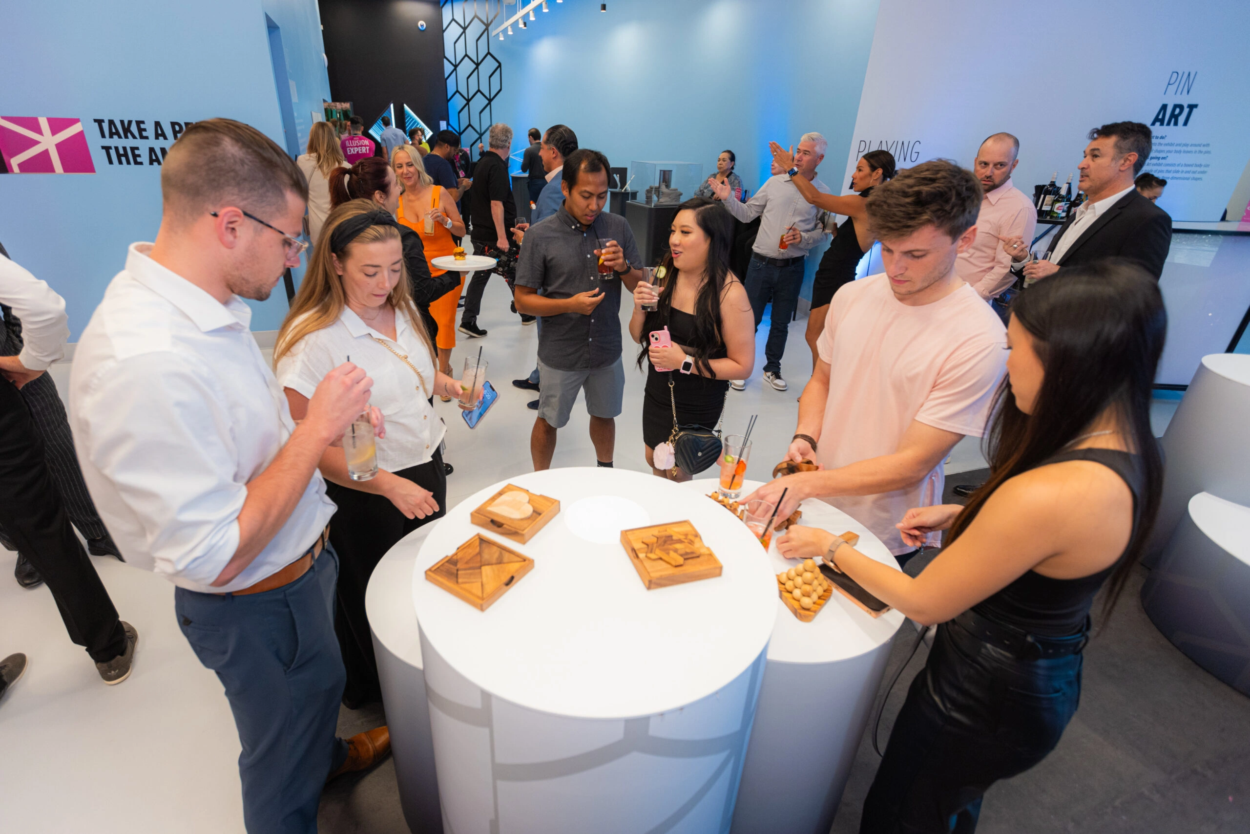 People are mingling and trying to solve brain games and puzzles at an event at Museum of Illusions.